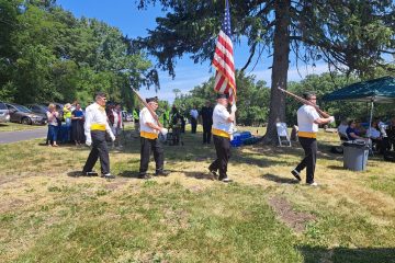 American Legion Post Color-Guard receives and raises the American flag.